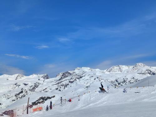 a group of people skiing down a snow covered mountain at Chez Umbus, centrale e immerso nel verde, grande terrazzo in Champoluc
