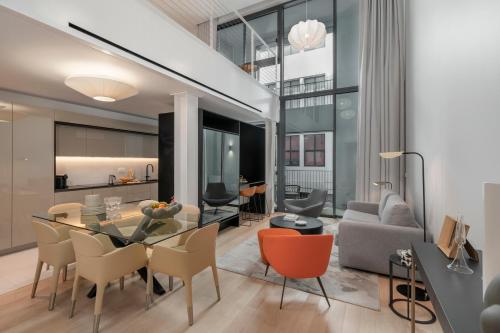a dining room and living room with a table and chairs at Savoy Insular Loft by An Island Apart in Funchal