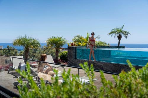 kobieta w bikini stojąca na skraju basenu w obiekcie Savoy Insular Loft by An Island Apart w Funchal