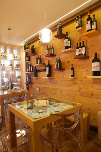 a tasting room with bottles of wine on the wall at Altavilla Locanda E Tipica Trattoria in Bianzone