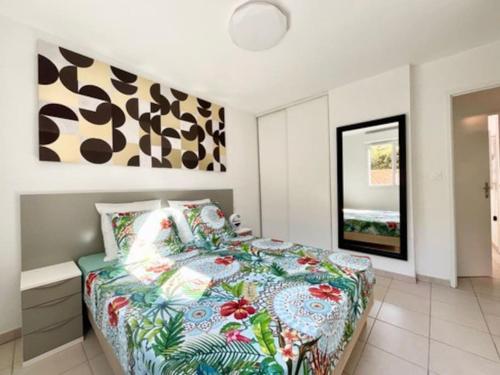 マルセイユにあるconfort et bien être Marseilleのベッドルーム1室(カラフルな掛け布団付きのベッド1台付)