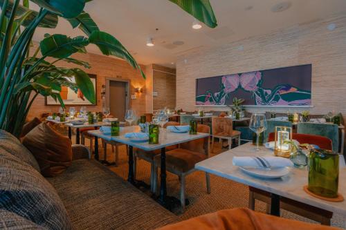 a restaurant with tables and chairs and a large screen at Kimpton Surfcomber Hotel by IHG in Miami Beach