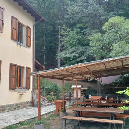 a patio with wooden benches and tables in front of a house at Rifugio Asqua in Poppi
