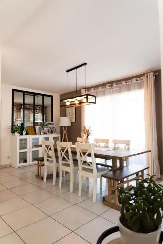 a kitchen and dining room with a table and chairs at La Maison de Jade & Spa in La Roche-de-Glun