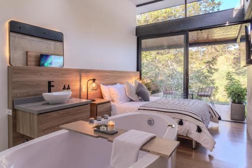 a bathroom with a bath tub and a bed at Soy Local Reserva Sajonia in Rionegro