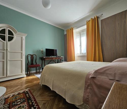 a bedroom with a bed and a desk and a television at Casa Torino Liberty in Turin