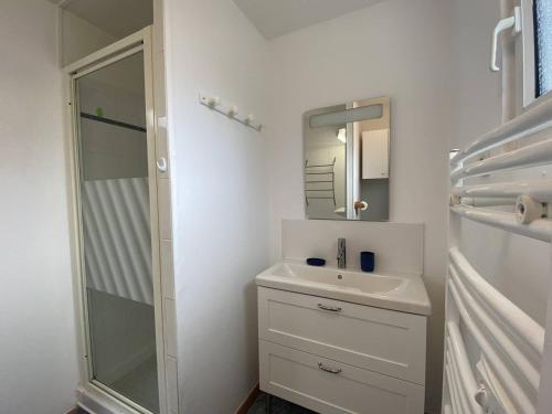 une salle de bain blanche avec un lavabo et une douche dans l'établissement Maison de pêcheur avec terrasse à 450m de la plage à TREGASTEL - Réf 184, à Trégastel