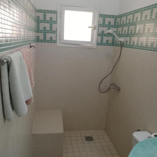 a bathroom with a shower with a window at KEUR DIAM - Maison de la Paix in Saly Portudal
