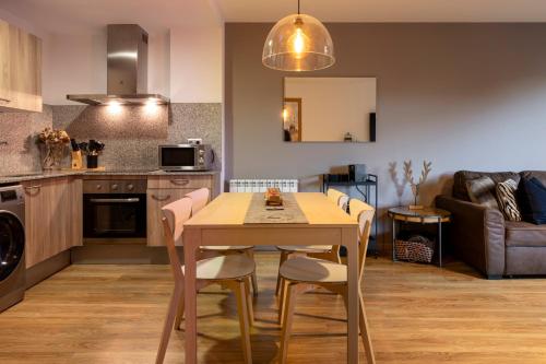a kitchen and living room with a wooden table and chairs at TOP Vistas Al Valle Arinsal - 6PAX - A Pie De Pistas & ESQUÍ - Free Parking l by BonesVacances in Arinsal