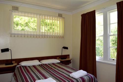 a bedroom with a bed and two windows at Clanwilliam in Blackheath