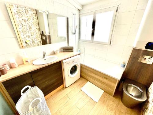a bathroom with a sink and a washing machine at Maison Marseille Vauban in Marseille