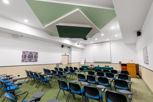 an empty room with chairs and a projection screen at Abacus Hotel in Sesto San Giovanni