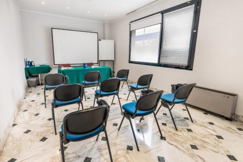 a conference room with chairs and a whiteboard at Abacus Hotel in Sesto San Giovanni