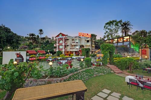 a park with a building in the background with a bench at Chacha Inn The Garden Retreat in Mount Ābu