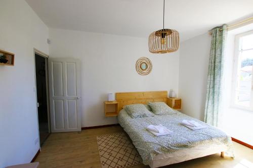 une chambre avec un lit avec deux serviettes dessus dans l'établissement Sous La Treille, à Saze