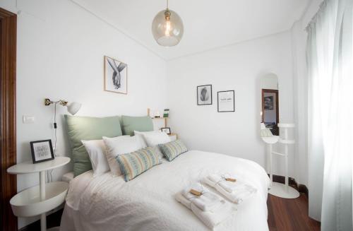 a white bedroom with a large white bed with white pillows at Bizkar Bare in Sopuerta