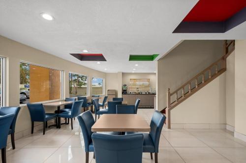 a dining room with tables and blue chairs at Quality Inn Sarasota I-75 in Sarasota