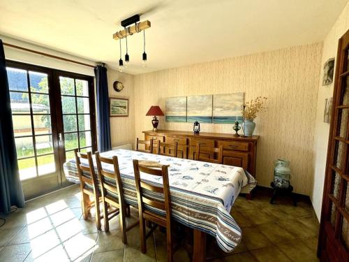 une salle à manger avec une table et des chaises et une fenêtre dans l'établissement Ker-Neo Maison familiale bretonne - Etel, à Étel