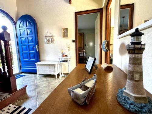 une chambre avec une porte bleue et une table avec une photo dans l'établissement Ker-Neo Maison familiale bretonne - Etel, à Étel