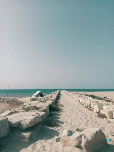 a path on the beach with rocks and the ocean at Villa avec piscine privée in Potinville