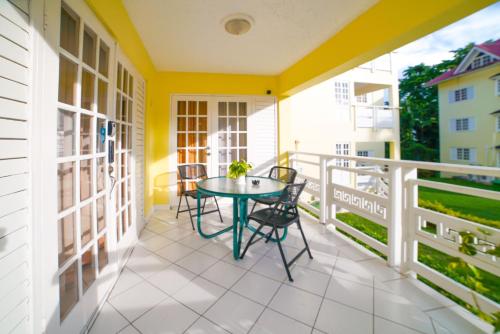 a patio with a table and chairs on a balcony at Simply Mystical in Ocho Rios