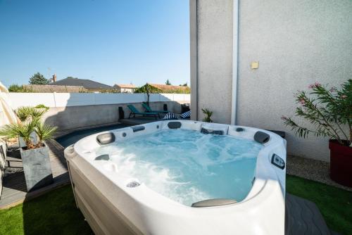 a jacuzzi tub on the patio of a house at La Maison de Jade & Spa in La Roche-de-Glun