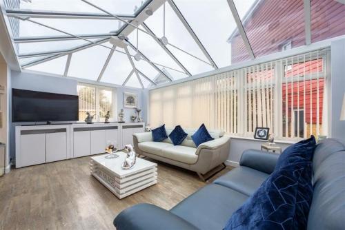 a living room with a blue couch and a tv at Charming Essex Hideaway in Southend-on-Sea