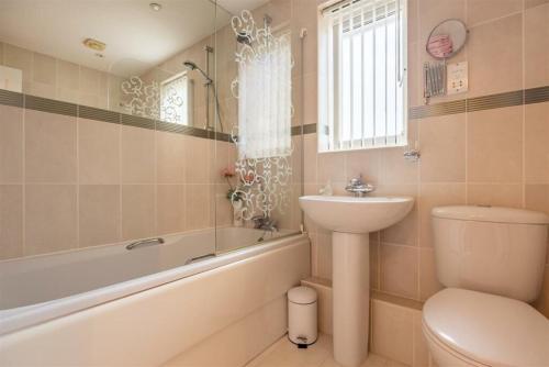 a bathroom with a sink and a toilet and a bath tub at Charming Essex Hideaway in Southend-on-Sea