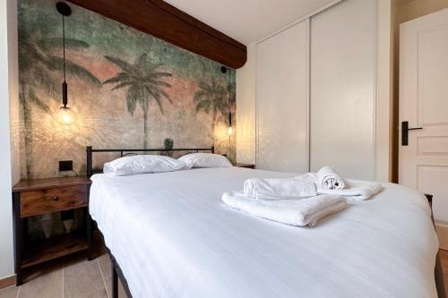 a bedroom with a white bed with towels on it at MACE Appartement avec SPA dans quartier Historique Exclusif Calme Coeur d'Antibes in Antibes