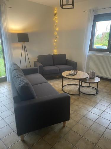 a living room with a couch and a table at Clair Matin - Maison avec jardin privatif in Crécy-en-Ponthieu