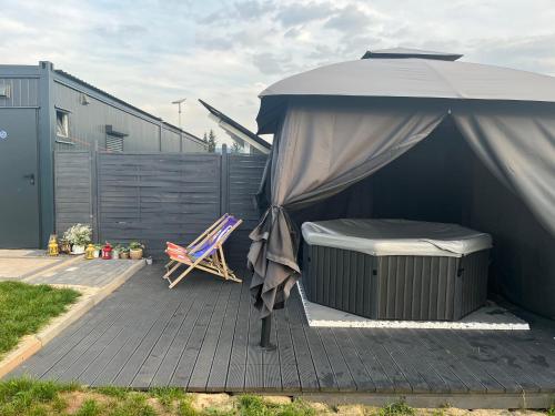 a bed and an umbrella on a patio at Tatra Glamp Okrzeszyn - Siec noclegowa Tatra Glamp in Okrzeszyn