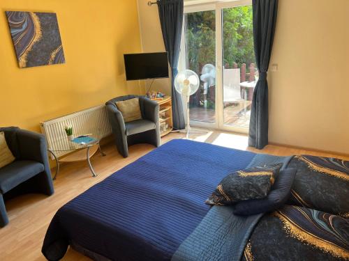 a bedroom with a bed and a chair and a window at Ubytovani Nikol in Brno