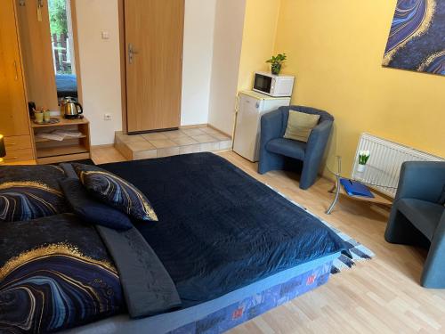a bedroom with a large bed and a chair at Ubytovani Nikol in Brno