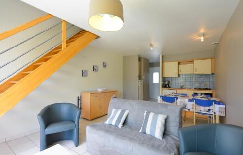 un salon avec un canapé et une cuisine dans l'établissement Le Clos de la Plage TY FANCH, à Erdeven