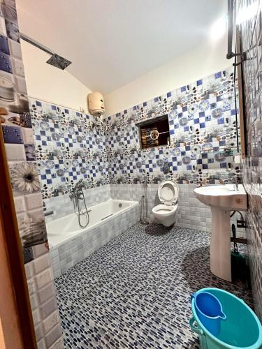 a bathroom with a tub and a toilet and a sink at RED HOUSE - AGONDA BEACH in Agonda