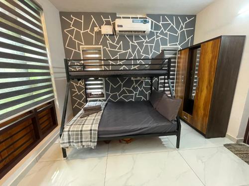 a room with a black bench in front of a wall at Varkala Life Homestay in Varkala