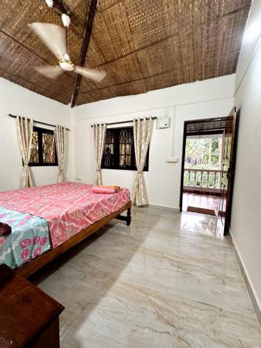 a bedroom with a bed and a ceiling fan at RED HOUSE - AGONDA BEACH in Agonda
