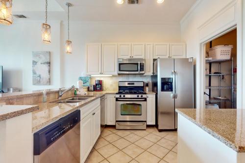 a kitchen with white cabinets and stainless steel appliances at The Wharf 906 in Orange Beach