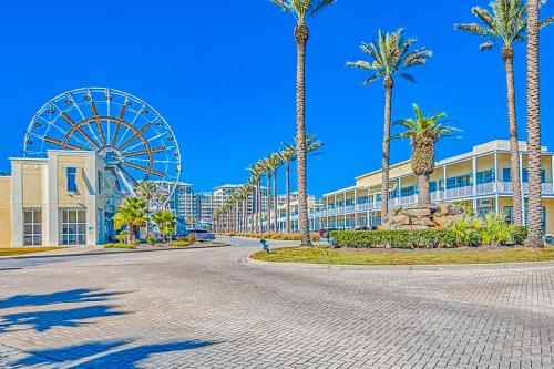 a city street with a ferris wheel and palm trees at The Wharf 906 in Orange Beach