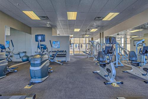 a gym with rows of treadmills and machines at The Wharf 406 in Orange Beach