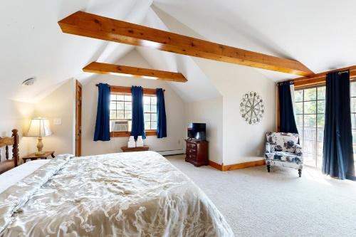 a bedroom with a large bed with blue curtains at Rivers Bend Retreat in Cavendish