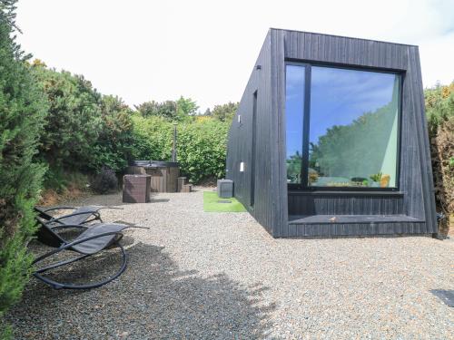 a small wooden house with a large window on the side at Stargazer in Kildermot Cross Roads
