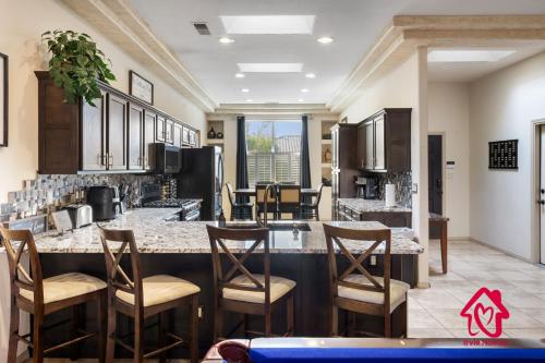 a kitchen with a large island with bar stools at Desert Hills - An Irvie Home in Albuquerque