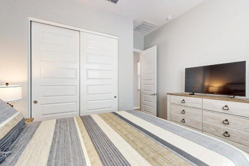 a bedroom with a large bed and a tv at Serenity 195 in Buckeye