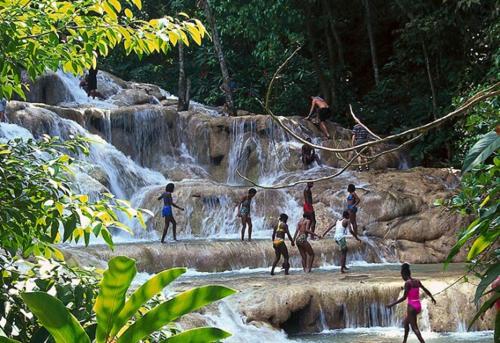 a group of people standing in front of a waterfall at Simply Mystical in Ocho Rios