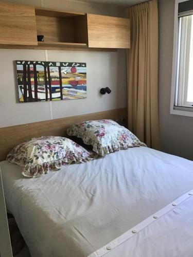 łóżko z dwiema poduszkami w sypialni w obiekcie MH 557 TOUT confort 40m2 3ch dont suite parentale 2 salles de bain avec vue sur forêt dans camping 4 étoiles w mieście Saint-Julien-en-Born