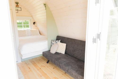 a small room with a couch and a bed at De verpozing - Vakantiehuisjes in Milsbeek
