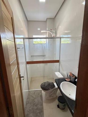a bathroom with a shower and a toilet and a sink at Flat 2 Suítes, piscina e churrasqueira em Alter in Alter do Chao