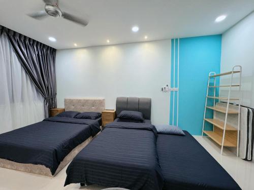 クチンにあるKuching Cozy Comfort 01 - Riverine Diamond Kuching 4 Paxの青い壁のベッドルーム1室(ベッド2台付)