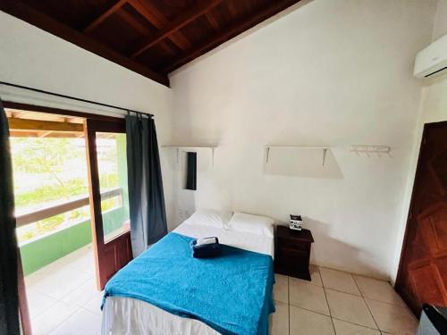 a bedroom with a bed with a blue blanket at SunHouse Praia do Rosa in Praia do Rosa